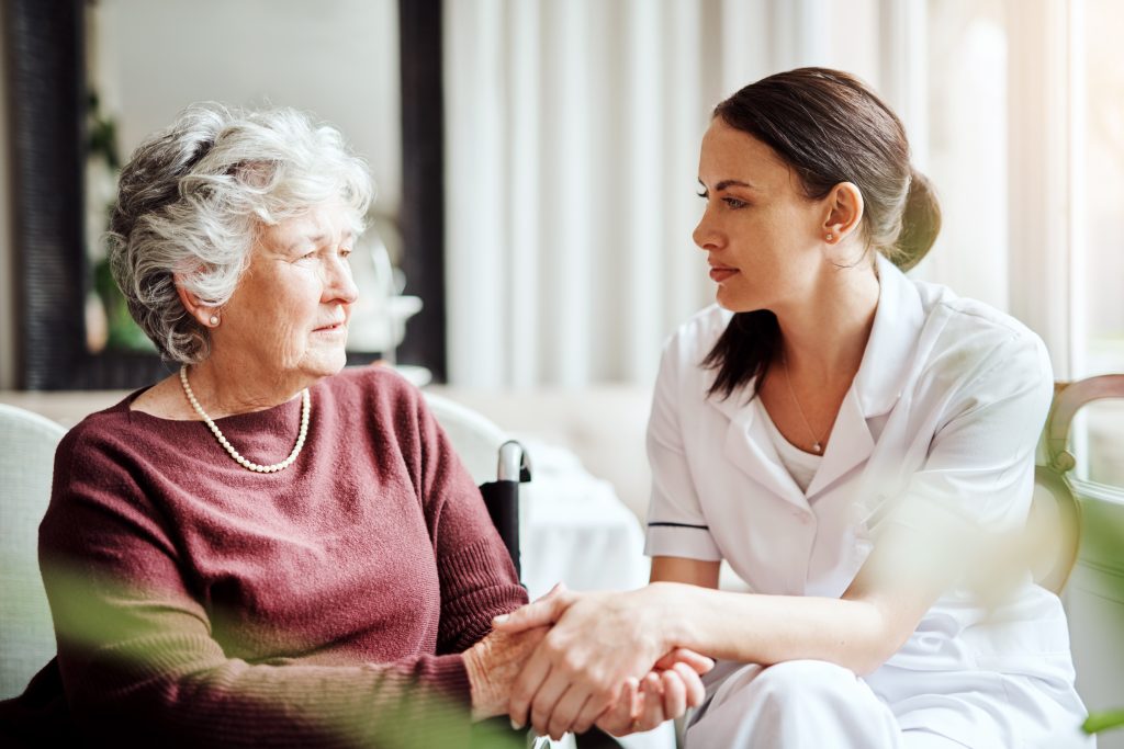 Shot of a young nurse talking with an elderly woman in a retirement home